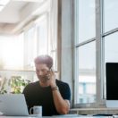 Businessman cold calling customers at his desk