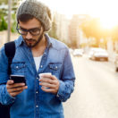 Young man using his cell phone; texting for small businesses concept