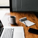 laptop with notepad on desk; how to write an executive summary