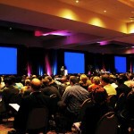 "Crowd waiting for speaker at business event"