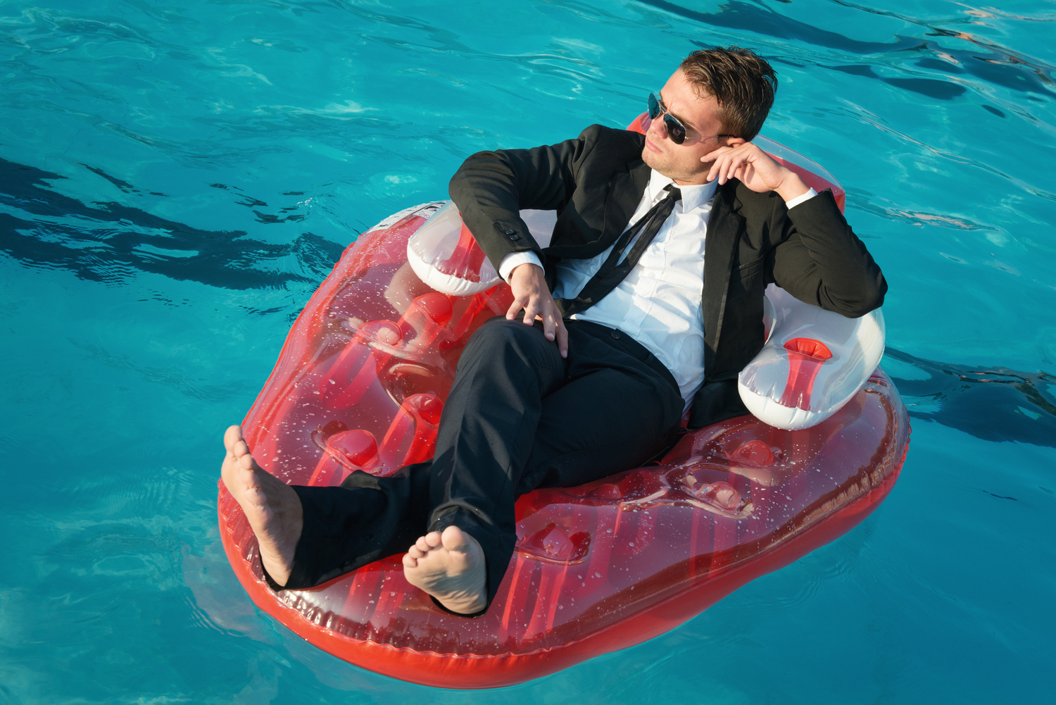 Businessman on call on pool floatie