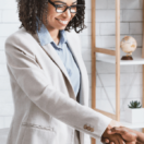 Woman shaking hiring managers hand after successfully completing an interview